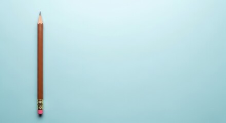 Naklejka premium Single wooden pencil on light blue background with copy space