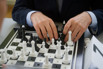 Blind grandmaster feels the chess pieces with both hands on a tactile board during a match;...