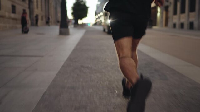 Man in black sportswear jogging past buildings on city street. Symbol of determination, mental strength, and balance of modern professional between digital life and energy
