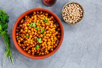 Roasted spicy chickpeas on grey background, top view, copy space for text