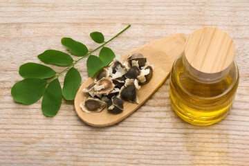 Moringa Oil and Seeds on wooden background