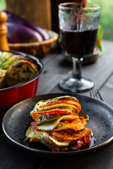 Plate of tasty Ratatouille on table and a glass of red wine