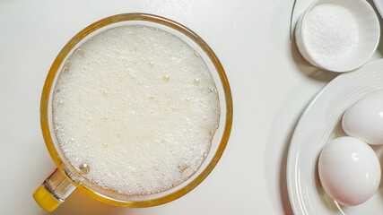 Effervescent froth commands a breakfast rite, invoking World Egg Day and National Foam Party with ethereal culinary whimsy