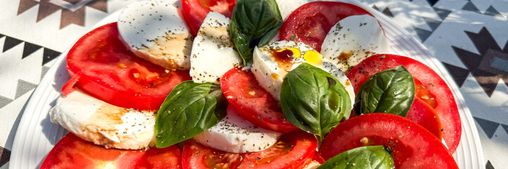 Juicy tomatoes and creamy mozzarella waltz with fresh basil, celebrating Mediterranean summer solstice and Italian Ferragosto in culinary harmony