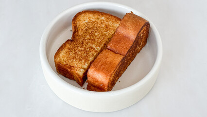 Golden-brown toast cozy in white ceramic vessel, igniting nostalgia for National Toast Day and quirky Homemade Bread Celebration