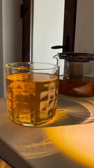 Golden sunlight dances through amber tea, evoking tranquil Hygge vibes and the ethereal calm of...