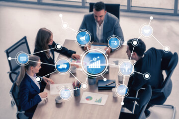 A dynamic business meeting in a modern office setting, showcasing a team of professionals collaborating on analytics and strategic growth approaches with digital visualizations. Tessel