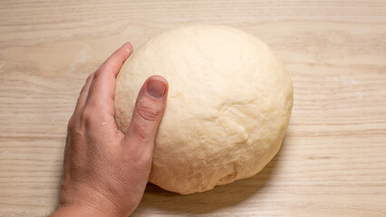 A nurturing hand gently molds a supple dough ball, invoking the tactile rhythms of Lammas and sourdough sanctuaries