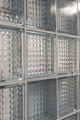 A close-up view reveals a textured glass block wall that diffuses natural light, adding depth and...