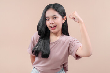 Asian woman in modern casual style posing with a strong arm gesture, smiling with confidence, representing empowerment, positivity, and youthful energy.