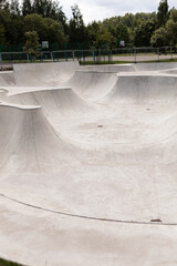 A modern concrete skatepark showcases various curves and ramps designed for extreme sports enthusiasts
