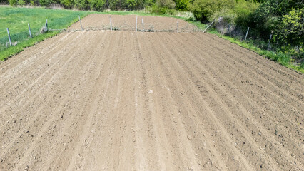 Aerial view of freshly plowed agricultural field prepared for planting crops during spring in a...