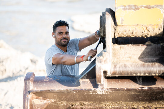 Construction worker operating excavator on site