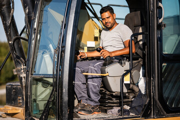 Construction worker driving excavator at building site