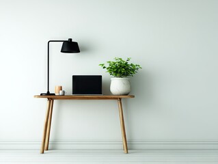 A minimalist wooden console table, accented with a black lamp, laptop, and potted plant, sits against a light gray wall, creating a tranquil and inviting workspace.