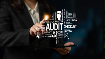 A business professional interacts with a digital tablet showcasing key audit terms, emphasizing the...