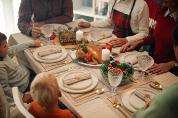 Family enjoying christmas dinner with roasted chicken and candles