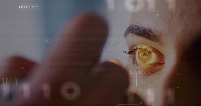 Scanning human eye and index fingertip projecting HUD graphics in tech station, with numeric codes