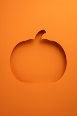 A vertical creatively styled pumpkin cutout in an orange background, perfect for Halloween...