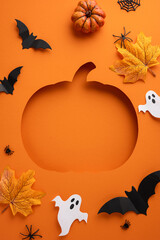 Festive vertical Halloween-themed orange background featuring a pumpkin cutout, bats, ghosts,...