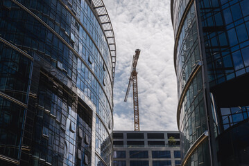 Fototapeta premium Building crane bewteen office buildings in Warsaw, Poland