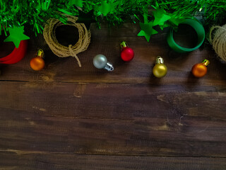 Christmas decorations are arranged on a brown wooden surface.