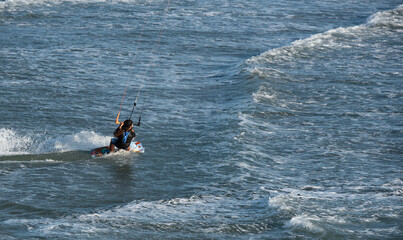 Kitesurfer enjoying the waves on a sunny day
