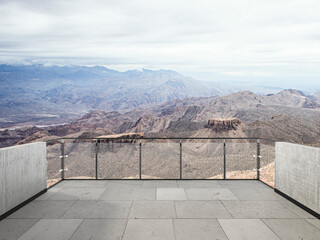 Panoramic desert mountain landscape with dramatic cloudy sky, rocky hills, dry valley, and scenic...