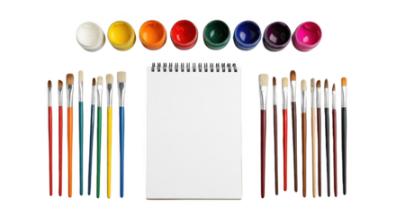 A collection of paintbrushes and paint pots are arranged around a blank spiralbound notebook, isolated on a transparent background