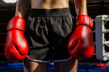 Closeup of red boxing gloves on fighter in the ring
