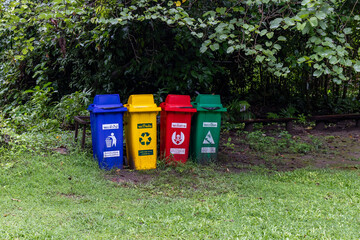 Different colors of Recycling Bins Placed in Natural Surroundings for Environmental Awareness.