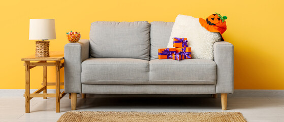 Interior of modern living room decorated for Halloween with sofa, lamp and table