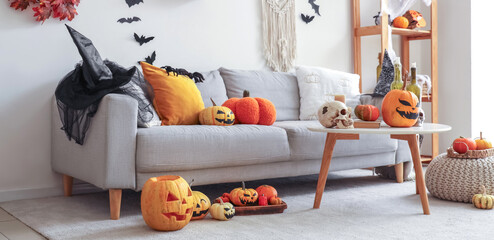 Interior of living room decorated for Halloween with sofa, table and pumpkins
