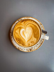 Close-up of a cappuccino with heart-shaped latte art on a gray table in a cozy cafe in Iceland