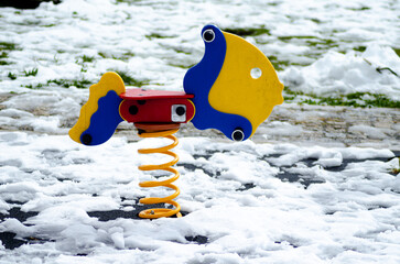 A colorful fish shaped spring rider in a snow covered playground The Sadness of Abandoned Fun
