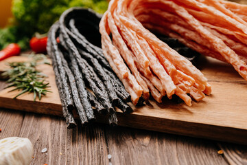 Variety of black and light meat sticks on board with herbs and spices, ideal for culinary display
