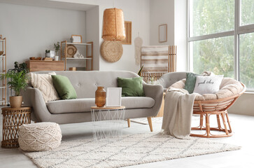 Interior of comfortable living room with soft couch, armchair, coffee table and window