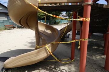 立ち入り禁止テープが貼られ使用禁止になった公園の滑り台