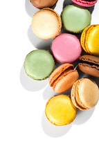 Macarons, macaroons, colorful assortment border design, vibrant pink, yellow, green, brown French pastries creamy fillings, macaroon isolated on white background, flat lay, top view vertical design 