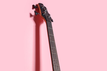 Modern electric guitar on pink background, closeup