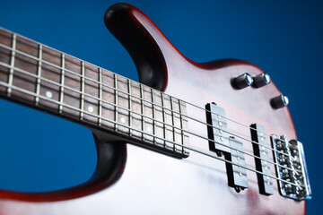 Modern electric guitar on dark blue background, closeup