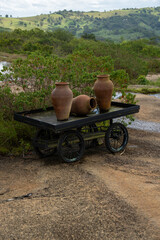 botija de barro ou barrio de barro com flores e um carrinho (clay pot or clay barrio with flowers and a cart) 