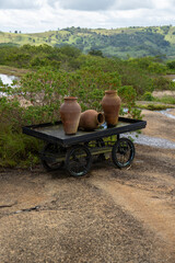 botija de barro ou barrio de barro com flores e um carrinho (clay pot or clay barrio with flowers and a cart) 
