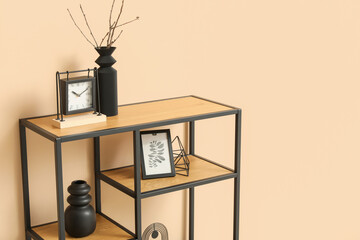 Black shelf unit with stylish decor near beige wall