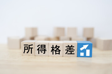 所得格差や賃金格差を表す木製ブロックとグラフの概念イメージ