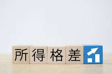 所得格差や賃金格差を表す木製ブロックとグラフの概念イメージ