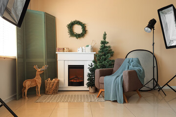 Photo shoot of living room with fireplace, armchair and Christmas tree in studio