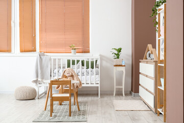 Interior of nursery with crib, tables and plants