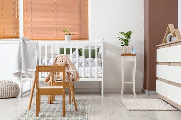 Interior of nursery with crib, tables and plants