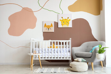 Interior of nursery with crib, table and armchair